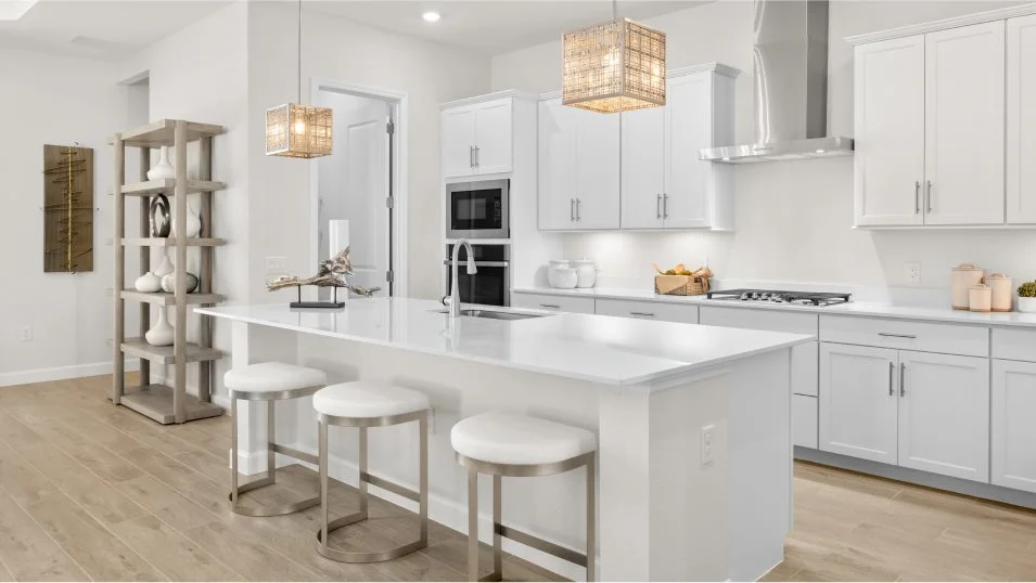 Kitchen with a white quartz island, wall oven and pendant lights