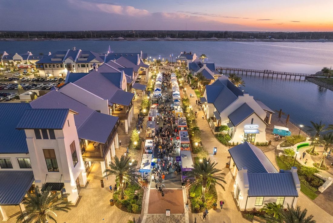 Evening aerial view of a waterfront dining and entertainment district in Lakewood Ranch